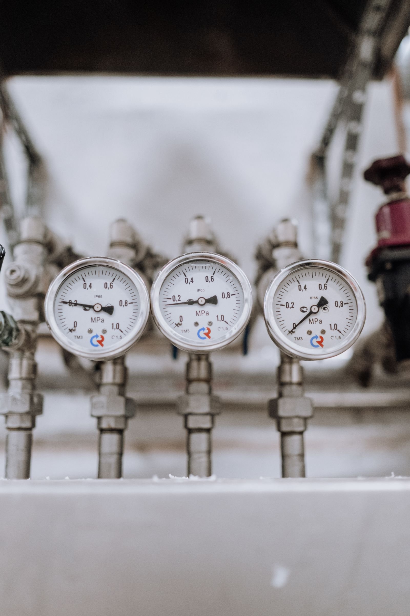 Three pressure gauges on compressed air pipework
