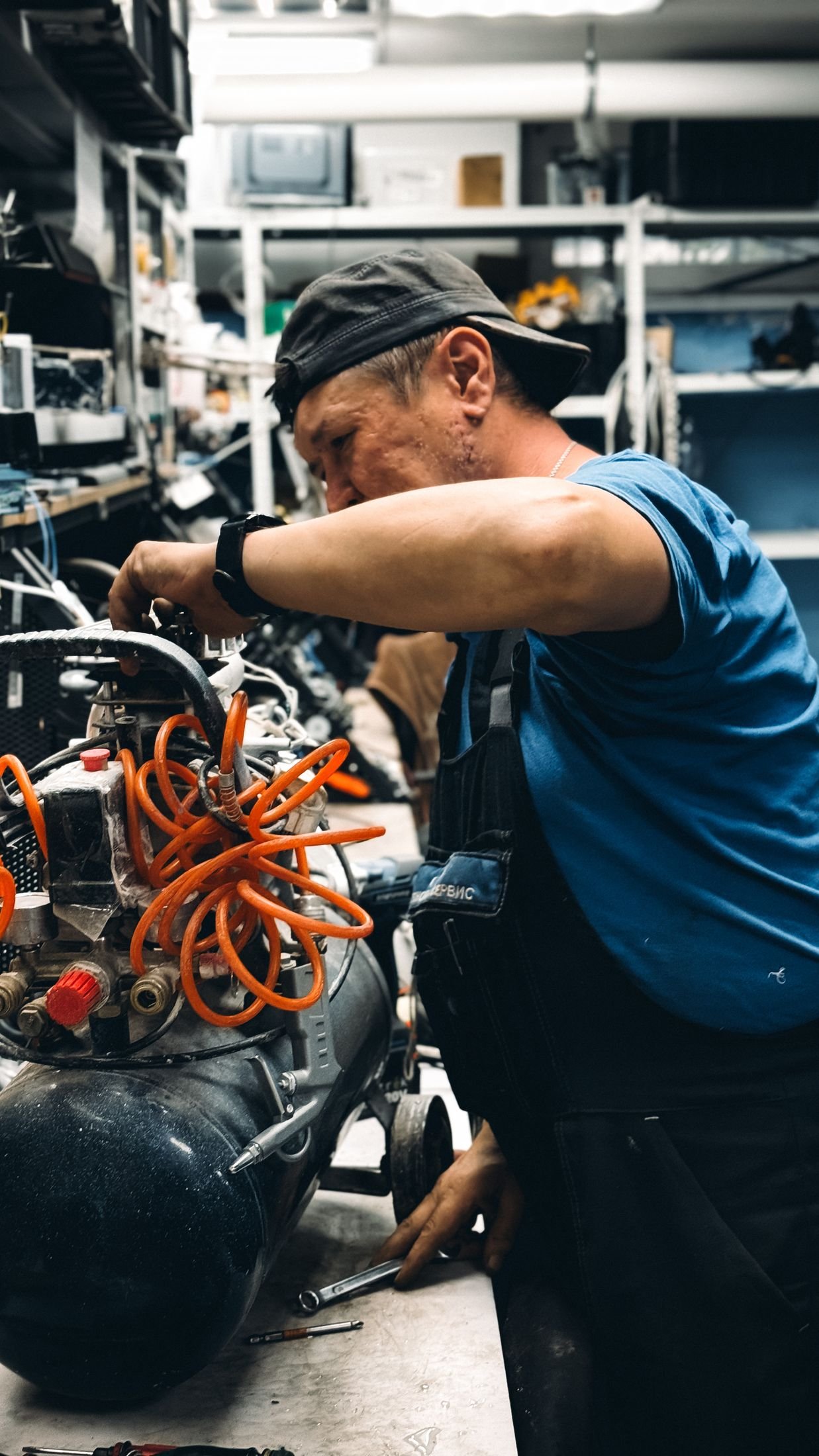 Engineer working on an industrial air compressor in a workshop