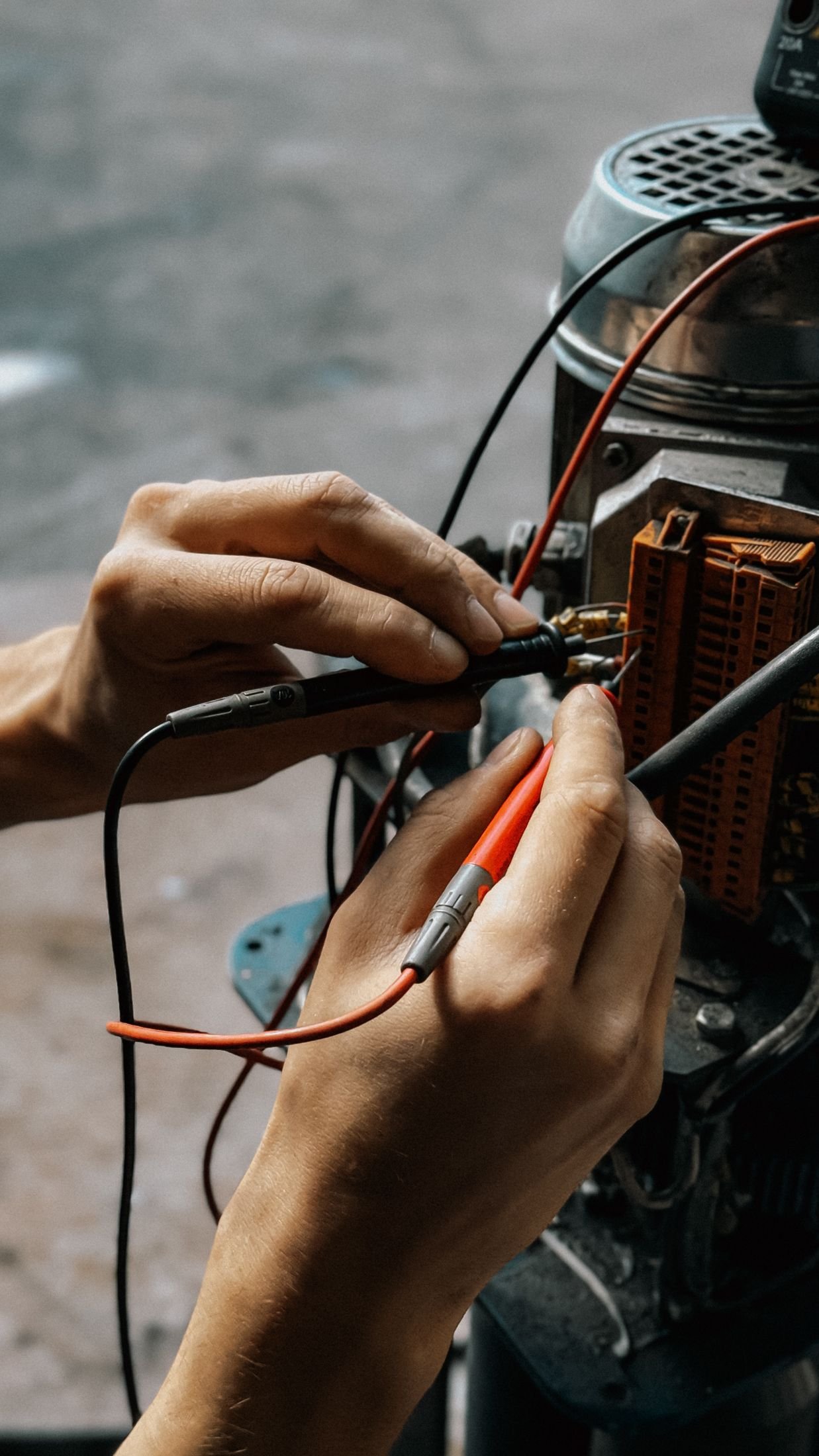 Engineer testing motor wiring with a multimeter