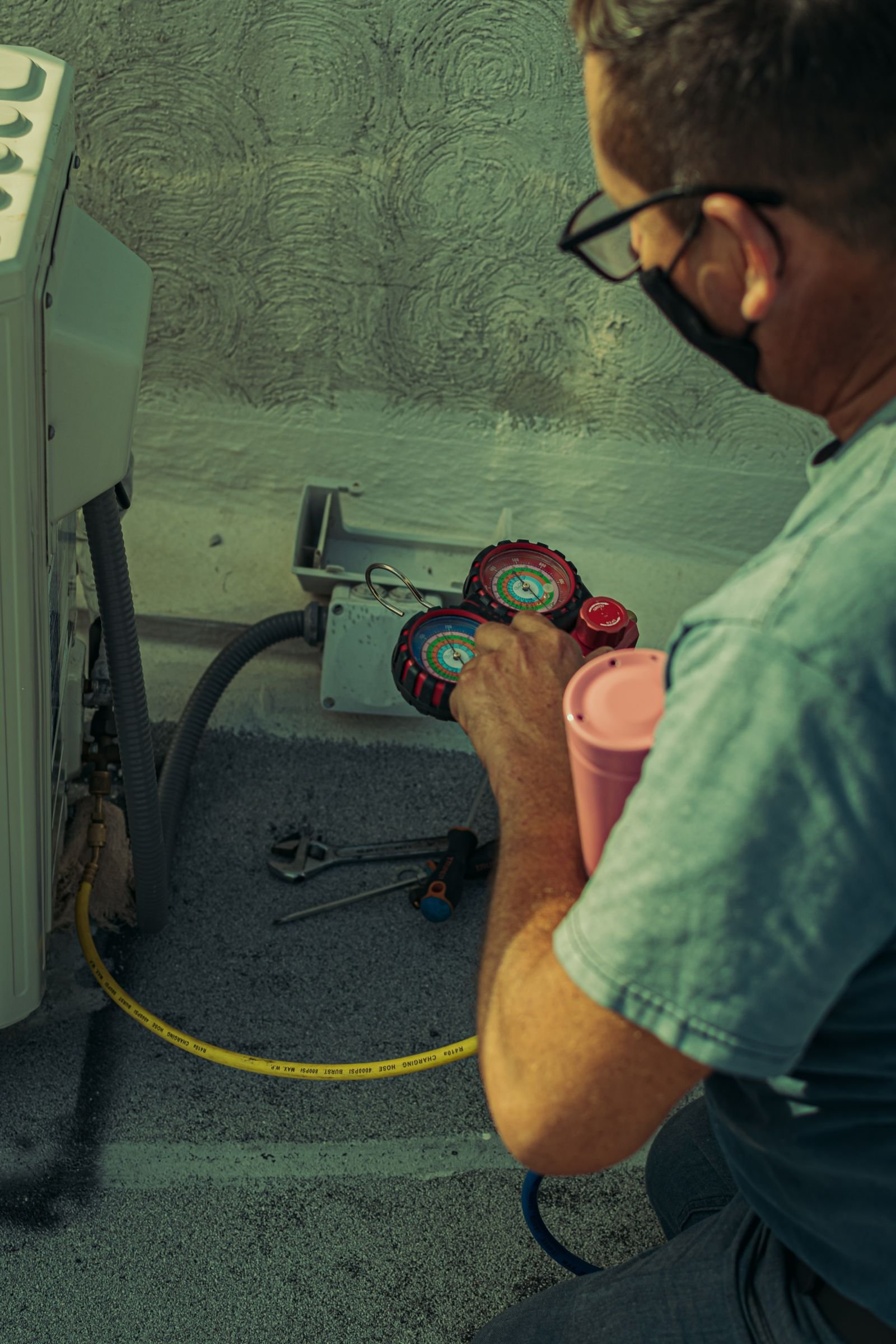 HVAC engineer working on an air conditioning system with gauges